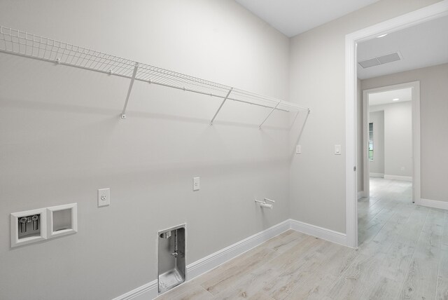 clothes washing area with light wood-type flooring and electric dryer hookup