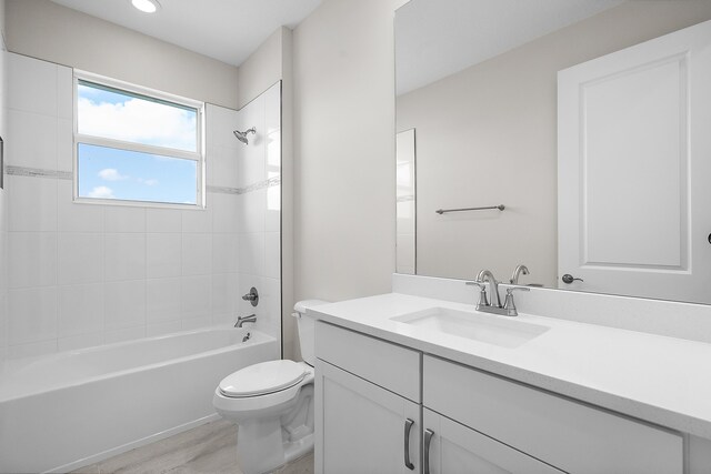 full bathroom featuring wood-type flooring, vanity, toilet, and tiled shower / bath