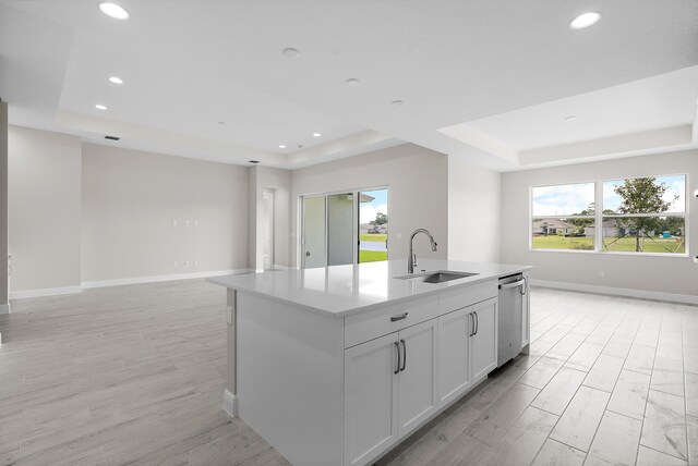 kitchen with white cabinets, sink, an island with sink, and a wealth of natural light