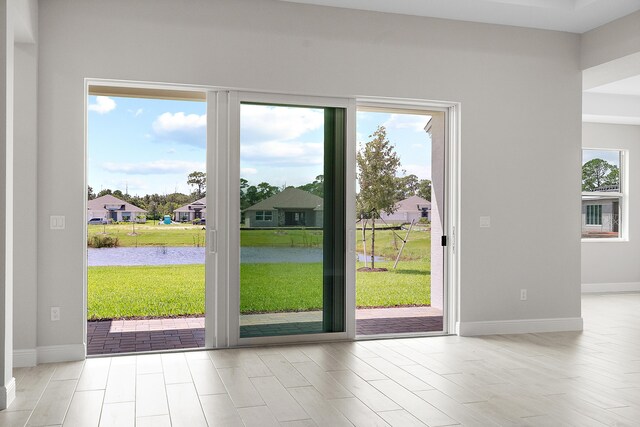 doorway to outside featuring light hardwood / wood-style floors and a water view