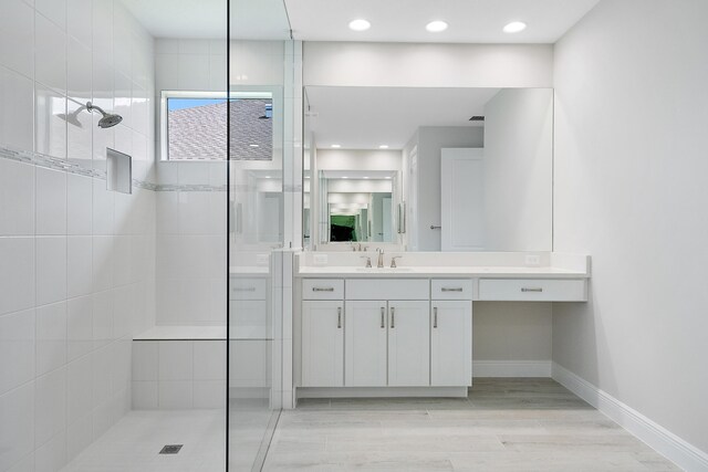 bathroom with vanity, hardwood / wood-style floors, and a tile shower