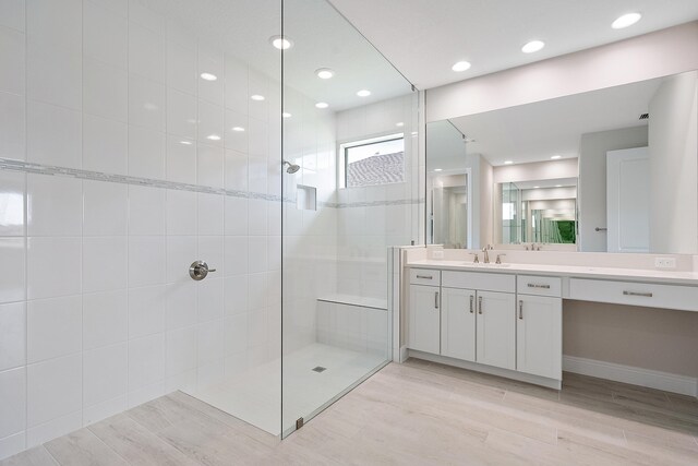 bathroom featuring vanity, hardwood / wood-style floors, and tiled shower