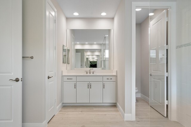 bathroom with vanity, toilet, and hardwood / wood-style flooring