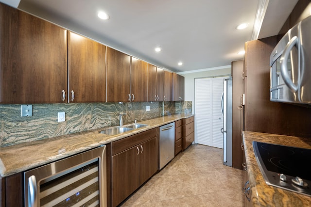 kitchen featuring wine cooler, light stone counters, sink, stainless steel appliances, and backsplash