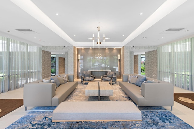 living room with a tray ceiling and a chandelier