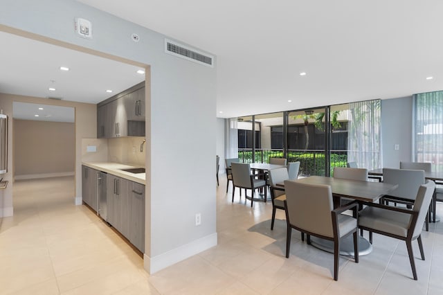 dining room featuring a healthy amount of sunlight, light tile patterned flooring, and sink