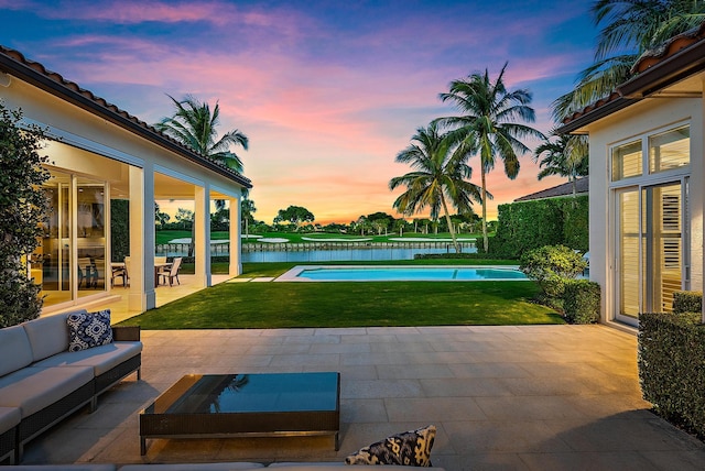 patio terrace at dusk featuring a water view and outdoor lounge area