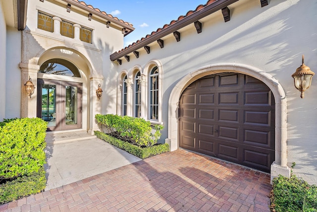 property entrance with a garage and french doors