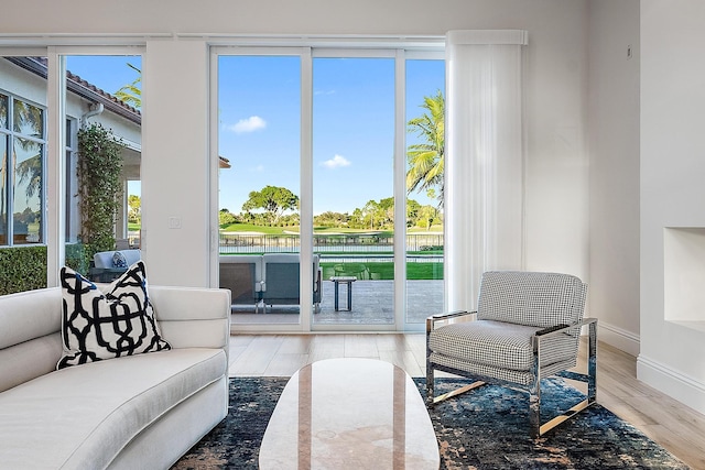 interior space featuring a healthy amount of sunlight, a water view, and hardwood / wood-style floors