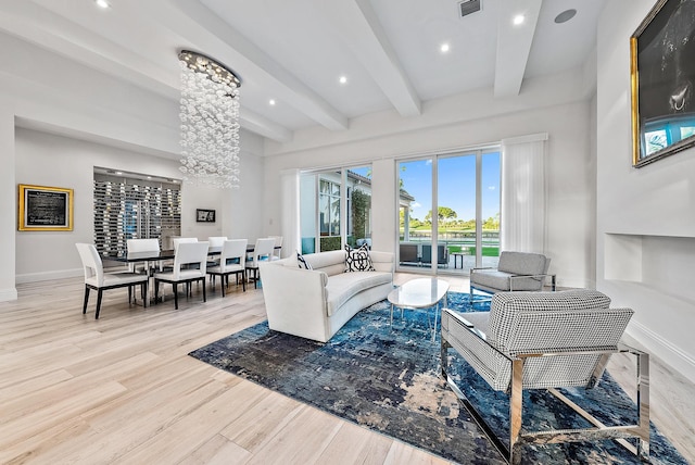 living room featuring an inviting chandelier, light wood-type flooring, and beam ceiling