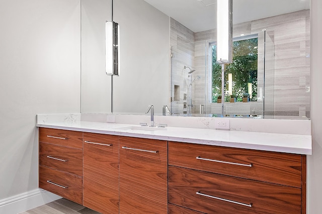 bathroom featuring walk in shower, vanity, and hardwood / wood-style flooring