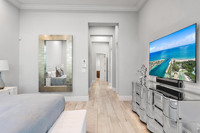 bedroom with crown molding and light hardwood / wood-style floors