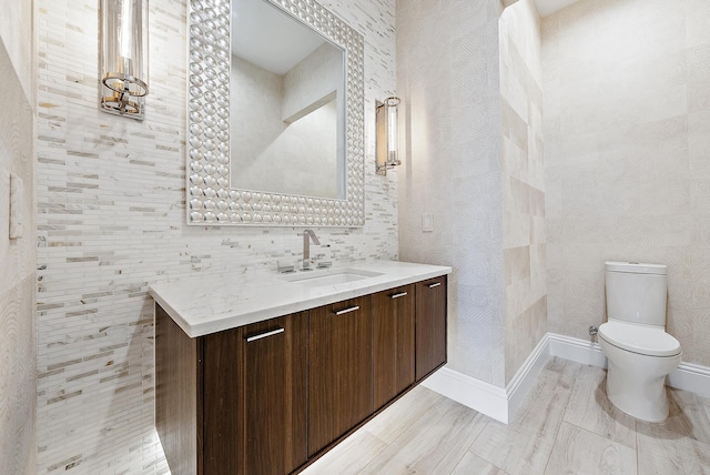 bathroom with hardwood / wood-style flooring, vanity, and toilet