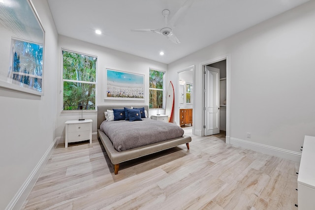 bedroom featuring light hardwood / wood-style floors, connected bathroom, and ceiling fan