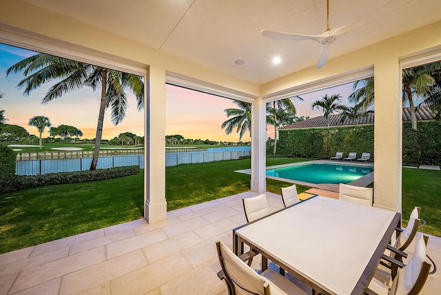 exterior space featuring ceiling fan, a fenced in pool, a yard, and a water view