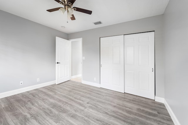 unfurnished bedroom with ceiling fan, light hardwood / wood-style flooring, and a closet