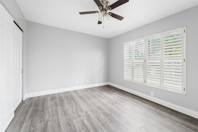 unfurnished bedroom with light wood-type flooring, ceiling fan, and a closet