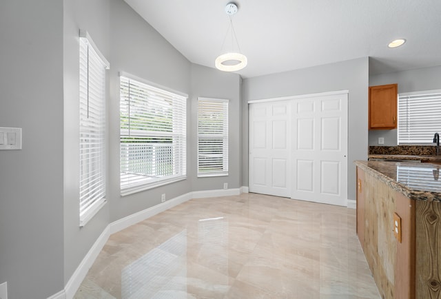 interior space with dark stone countertops and hanging light fixtures