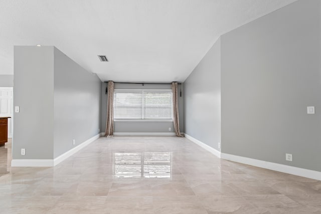 unfurnished room with vaulted ceiling