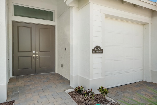 view of exterior entry with a garage