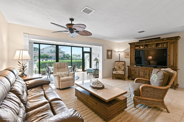 tiled living room featuring a textured ceiling and ceiling fan