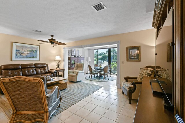 living room with light tile patterned floors, a textured ceiling, and ceiling fan