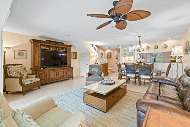 tiled living room featuring ceiling fan with notable chandelier