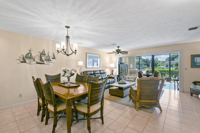 dining area featuring ceiling fan with notable chandelier, light tile patterned floors, and a textured ceiling