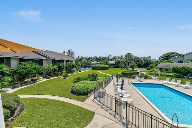 view of pool with a patio area and a yard