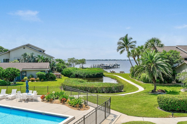 view of pool featuring a patio area, a yard, and a water view