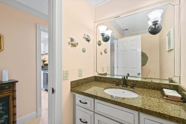 bathroom with tile patterned flooring, vanity, and crown molding