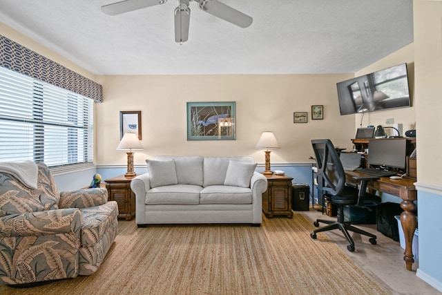 carpeted home office featuring ceiling fan