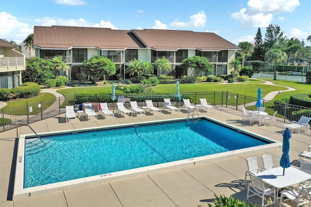 view of pool with a patio area and a yard