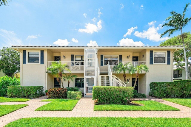 view of front of property featuring a front lawn and a balcony