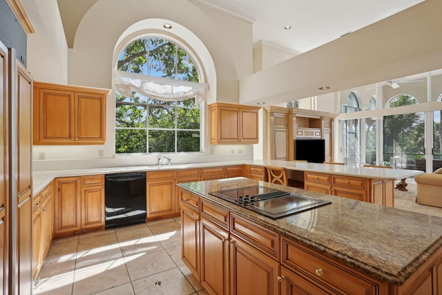 kitchen with sink, a center island, high vaulted ceiling, light tile patterned floors, and black appliances