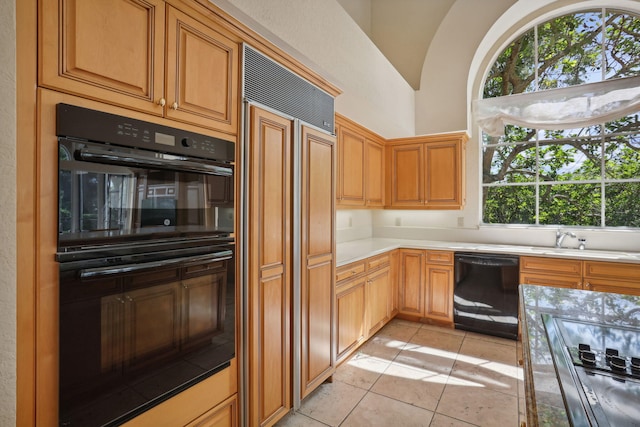 kitchen with black appliances, light tile patterned flooring, and lofted ceiling