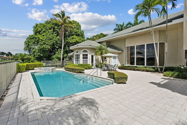 view of swimming pool featuring a patio area and an in ground hot tub