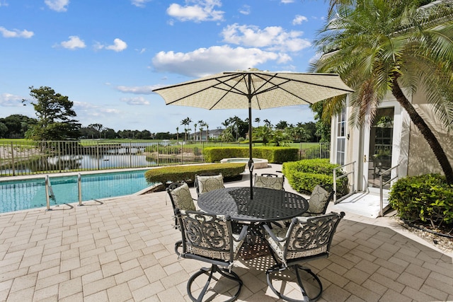 view of pool with a patio area and a water view