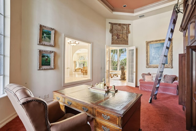 home office with dark colored carpet, a raised ceiling, a towering ceiling, and crown molding