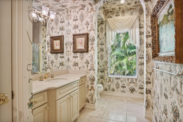 bathroom featuring a chandelier, tile patterned floors, vanity, and toilet