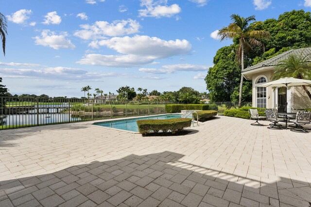 view of pool featuring a patio and a water view