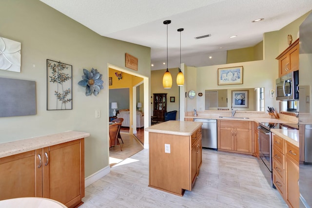 kitchen featuring stainless steel appliances, light wood-type flooring, sink, and a center island