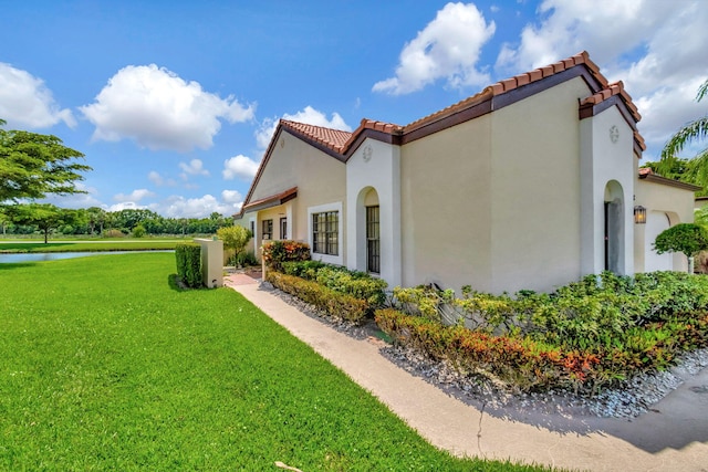 view of home's exterior featuring a lawn and a water view