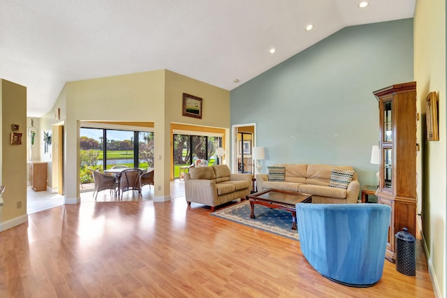 living room with ornate columns, light hardwood / wood-style flooring, and high vaulted ceiling