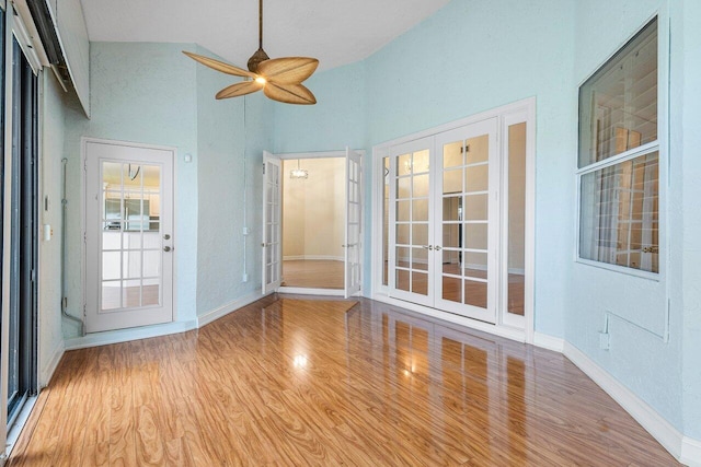 unfurnished sunroom featuring lofted ceiling, ceiling fan, and french doors