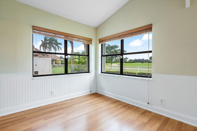 unfurnished room featuring light hardwood / wood-style floors, a healthy amount of sunlight, and vaulted ceiling