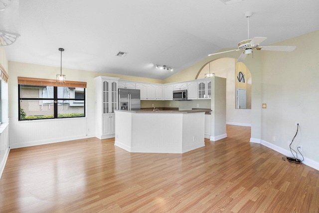 kitchen with light hardwood / wood-style flooring, white cabinetry, vaulted ceiling, and stainless steel appliances