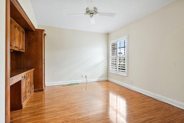 unfurnished living room featuring ceiling fan, a textured ceiling, and light hardwood / wood-style floors