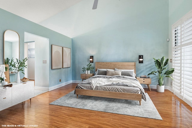 bedroom with high vaulted ceiling, wood-type flooring, and ceiling fan