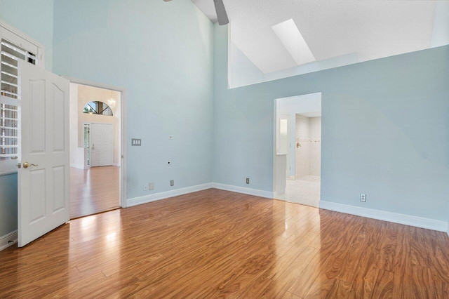 empty room featuring light hardwood / wood-style flooring and high vaulted ceiling